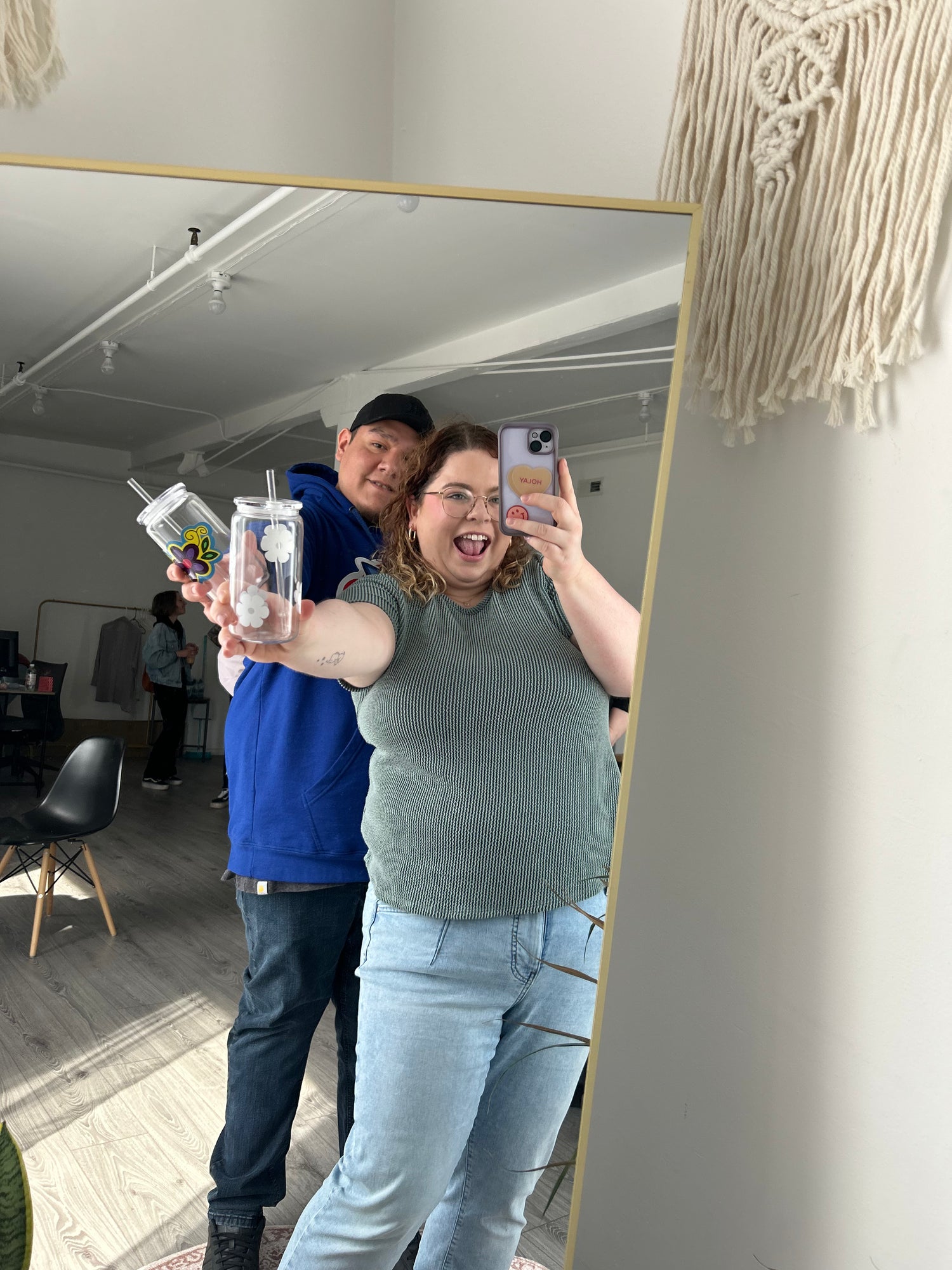 Happy N' Beyond Owners Meaghan and Tyler smiling holding tumblers